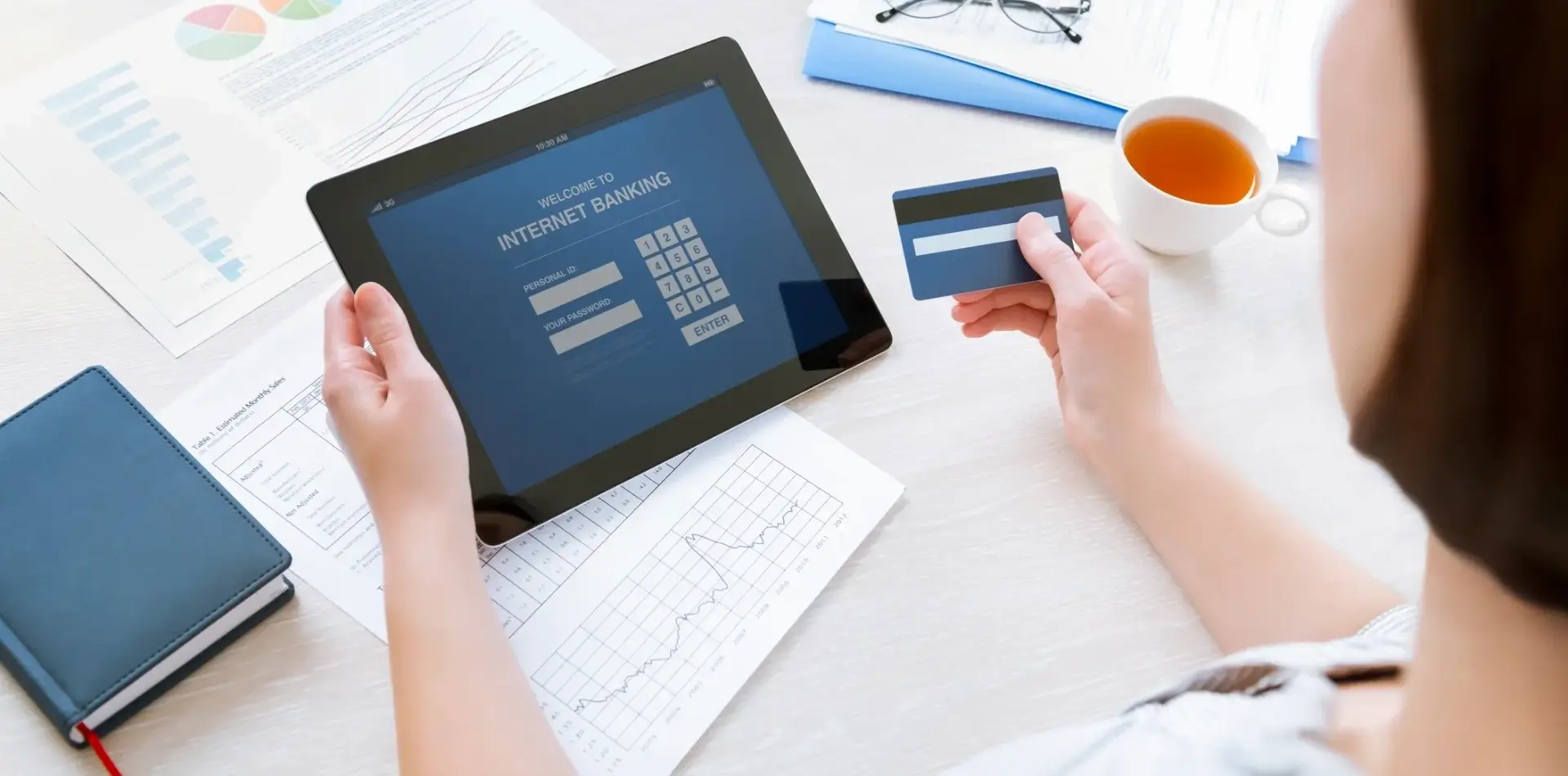 Person making an online payment using a tablet and credit card.